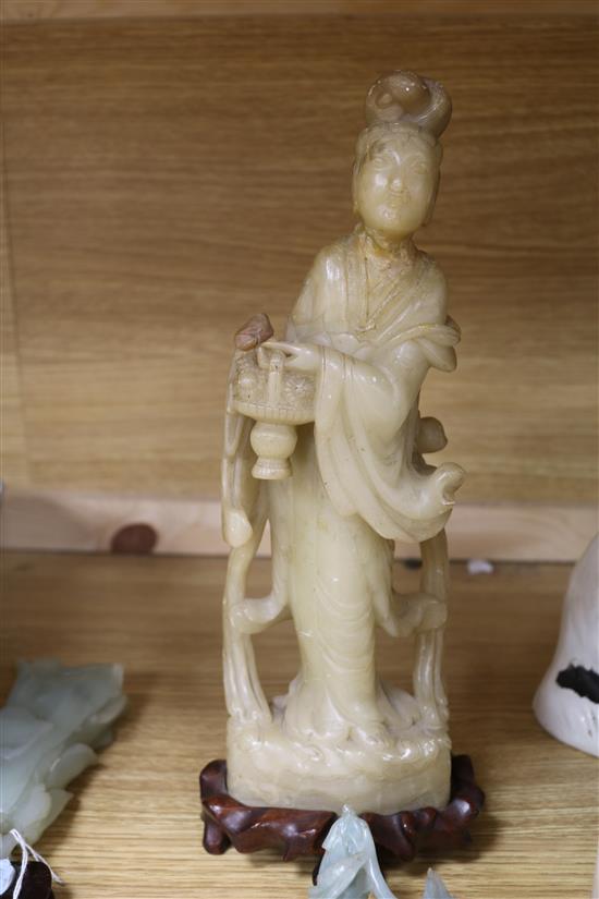 A Chinese celadon jade magnolia blossom, a jadeite figure of Guanyin, a pair of jadeite birds, a large soapstone figure of a lady and a